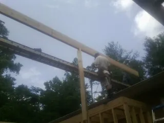 Carpenter setting a ridge beam over a new addition frame — Ice Dam Removal by Roofing Brothers in Tuscarora